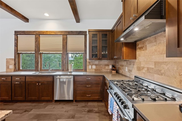 kitchen with beamed ceiling, dark hardwood / wood-style flooring, appliances with stainless steel finishes, sink, and decorative backsplash