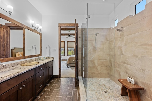 bathroom with plenty of natural light, ceiling fan, vanity, and a tile shower