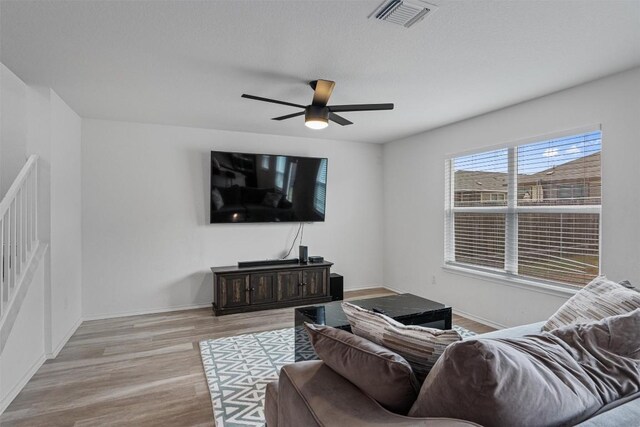 living room with ceiling fan and light hardwood / wood-style flooring