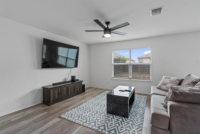 living room with ceiling fan and light hardwood / wood-style flooring