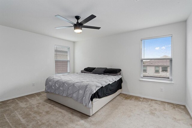 bedroom featuring light colored carpet and ceiling fan