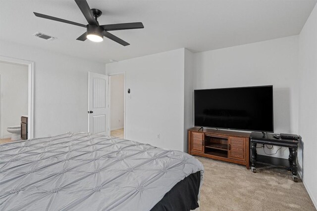 bedroom featuring connected bathroom, light colored carpet, and ceiling fan