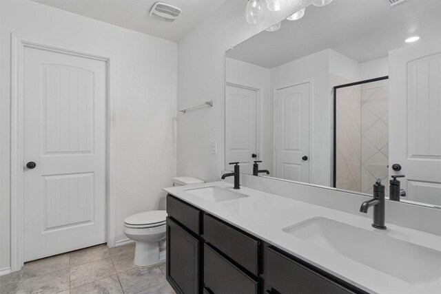 bathroom with vanity, toilet, an enclosed shower, and tile patterned flooring