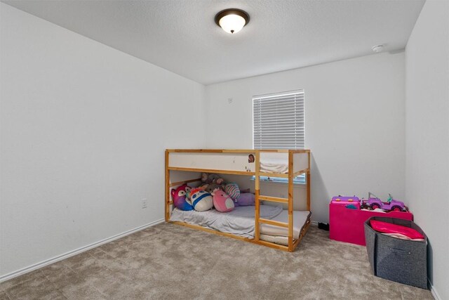 bedroom with light colored carpet and a textured ceiling