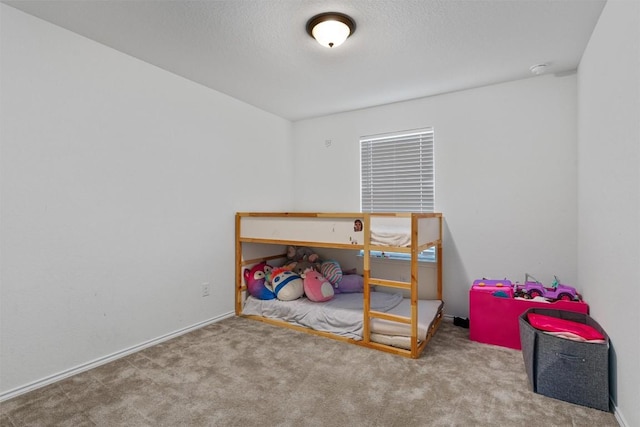 bedroom with a textured ceiling, baseboards, and carpet floors