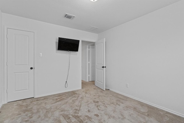 carpeted empty room featuring baseboards and visible vents