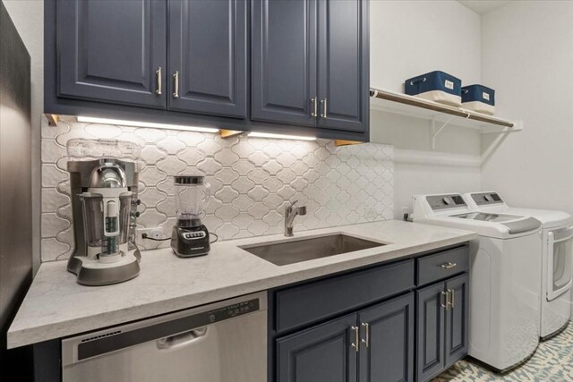 laundry area featuring cabinets, independent washer and dryer, and sink