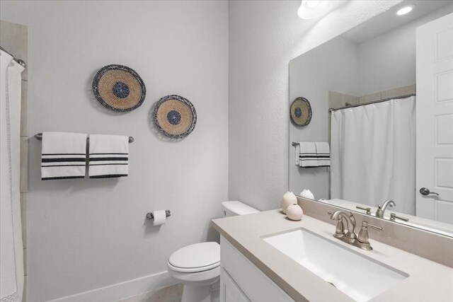 bathroom with vanity, toilet, and curtained shower