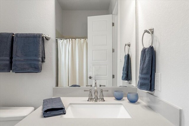 bathroom featuring vanity, toilet, and a shower with curtain