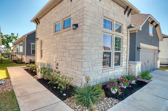 view of home's exterior featuring a garage and ac unit