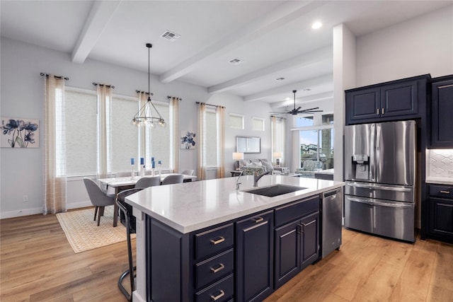 kitchen with light hardwood / wood-style flooring, ceiling fan with notable chandelier, stainless steel appliances, and sink