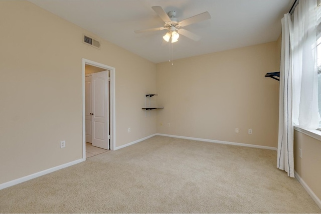 carpeted spare room with ceiling fan