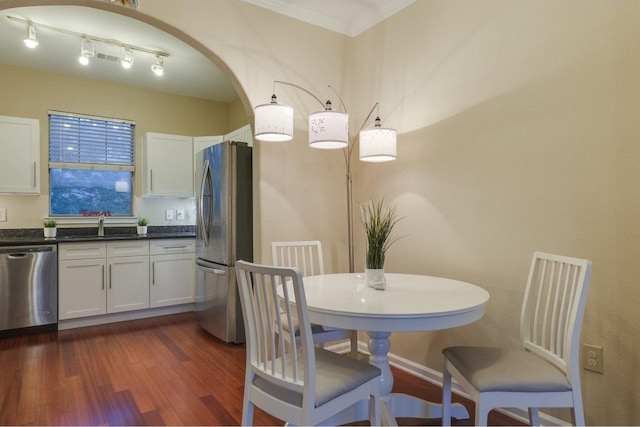 dining space featuring ornamental molding and dark hardwood / wood-style flooring