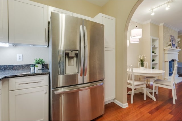 kitchen featuring ornamental molding, stainless steel fridge, white cabinetry, and wood-type flooring