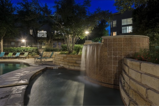 patio at twilight with a community pool