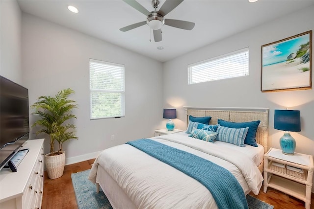 bedroom with ceiling fan, dark wood-type flooring, and multiple windows