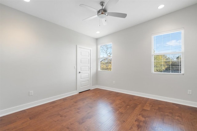 unfurnished room featuring plenty of natural light, dark hardwood / wood-style floors, and ceiling fan