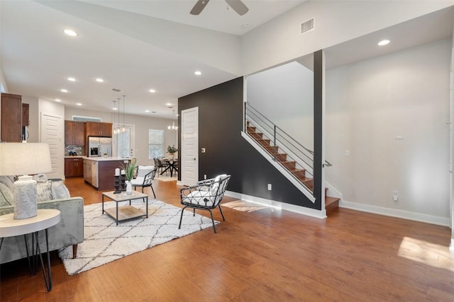 living room featuring ceiling fan and light hardwood / wood-style floors