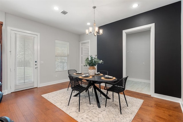 dining room with hardwood / wood-style flooring and a notable chandelier