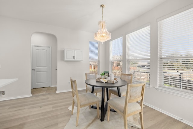 dining area with light hardwood / wood-style flooring and a chandelier