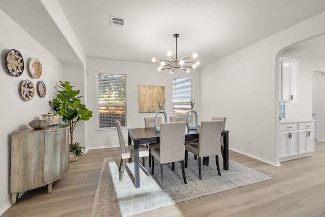 dining room featuring light wood-type flooring and a chandelier