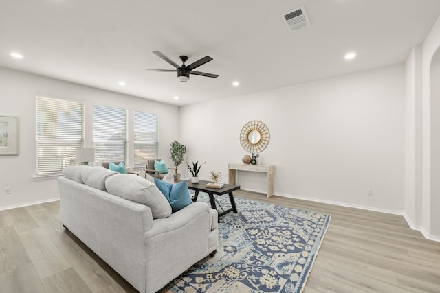 living room with light hardwood / wood-style flooring and ceiling fan