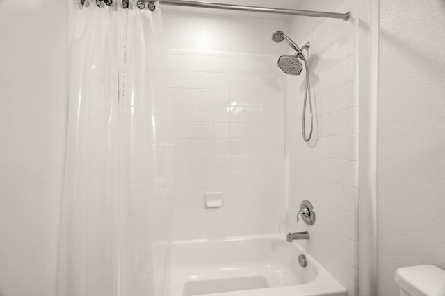 bathroom with shower / bath combo with shower curtain and toilet