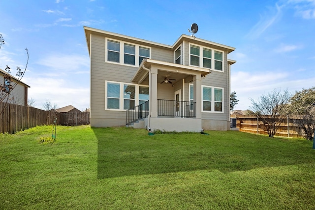 back of property featuring ceiling fan and a yard