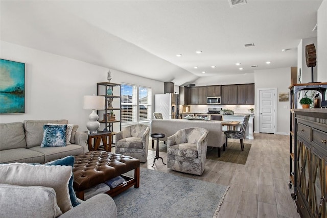 103 Samuel Blair Pass, Bastrop, TX 78602 - living area featuring vaulted ceiling, light wood-type flooring, and recessed lighting