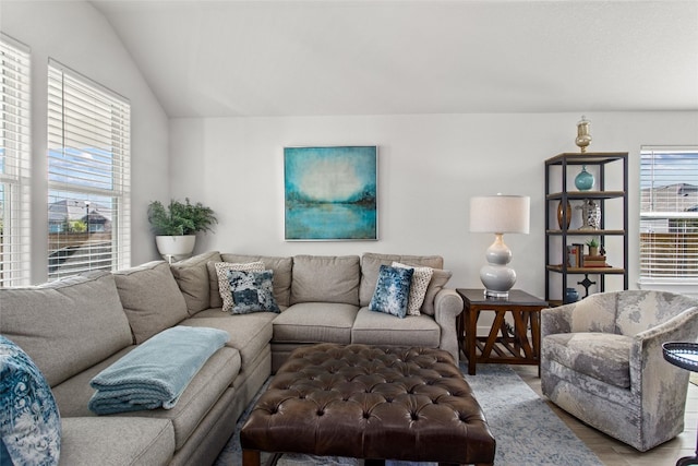 living room with a healthy amount of sunlight, vaulted ceiling, and light hardwood / wood-style flooring