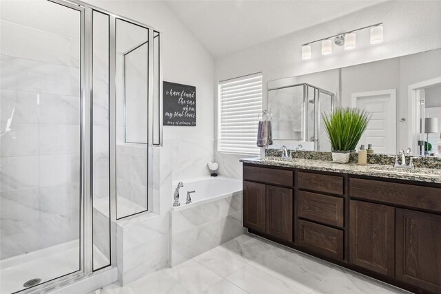 bathroom featuring vanity, vaulted ceiling, and shower with separate bathtub