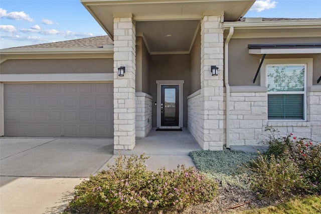 103 Samuel Blair Pass, Bastrop, TX 78602 - property entrance featuring stucco siding, an attached garage, driveway, and stone siding