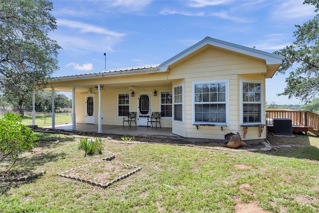 back of property featuring a lawn and ceiling fan