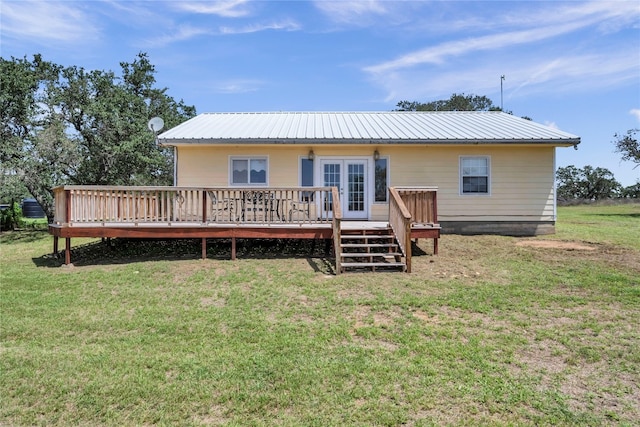 back of house with a deck and a lawn