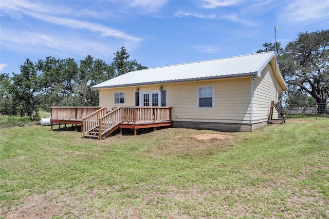 rear view of property featuring a yard and a wooden deck