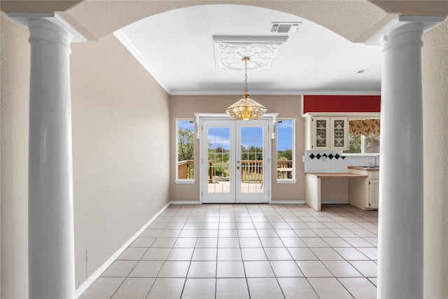 unfurnished dining area with ornamental molding, a chandelier, ornate columns, and light tile patterned floors