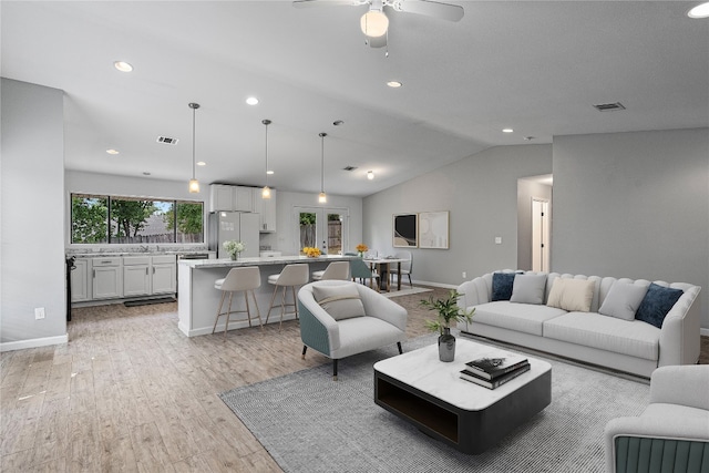 living room with vaulted ceiling, ceiling fan, and light hardwood / wood-style floors