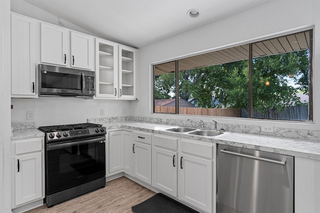 kitchen with appliances with stainless steel finishes, white cabinetry, and sink