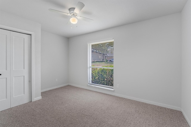 unfurnished bedroom with a closet, ceiling fan, and carpet floors