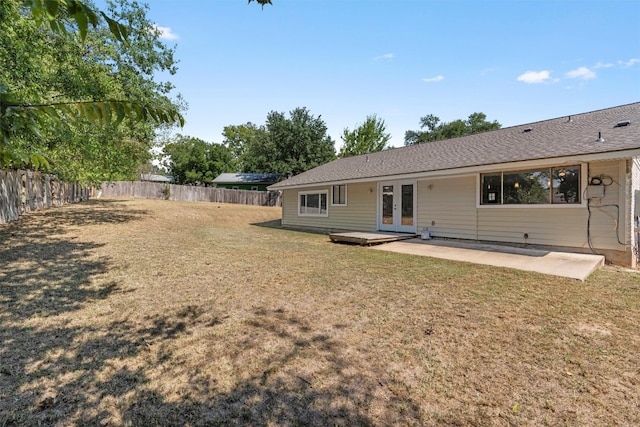 rear view of property with french doors, a lawn, and a patio