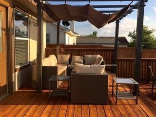 wooden terrace with a pergola and an outdoor hangout area