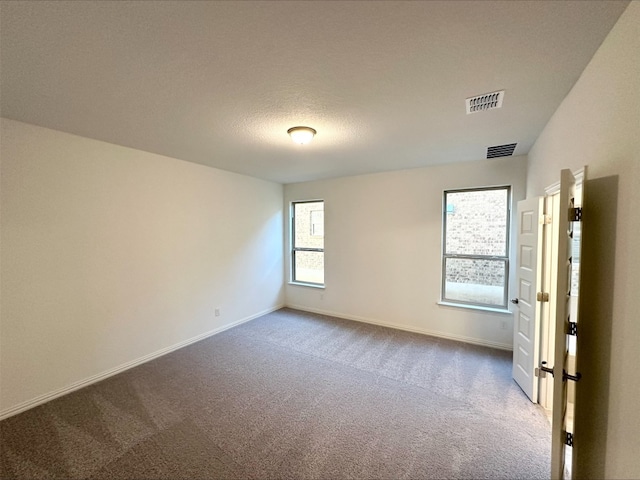 carpeted spare room featuring a textured ceiling