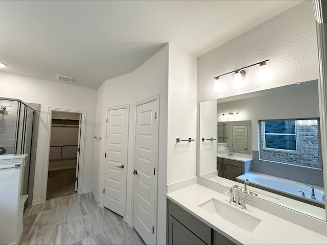 bathroom featuring separate shower and tub and vanity