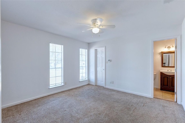 carpeted spare room featuring ceiling fan and sink