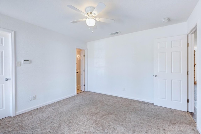 spare room featuring light colored carpet and ceiling fan