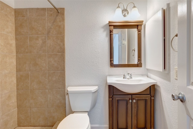 bathroom with vanity, toilet, and a shower