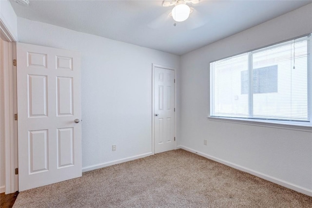 unfurnished bedroom featuring ceiling fan, light carpet, and a closet