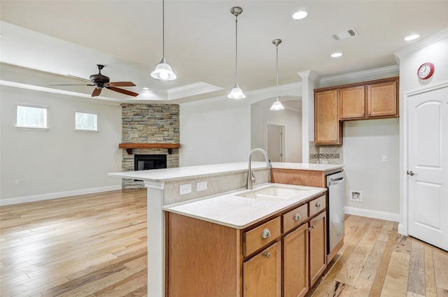 kitchen with sink, a fireplace, light hardwood / wood-style flooring, a center island with sink, and ceiling fan