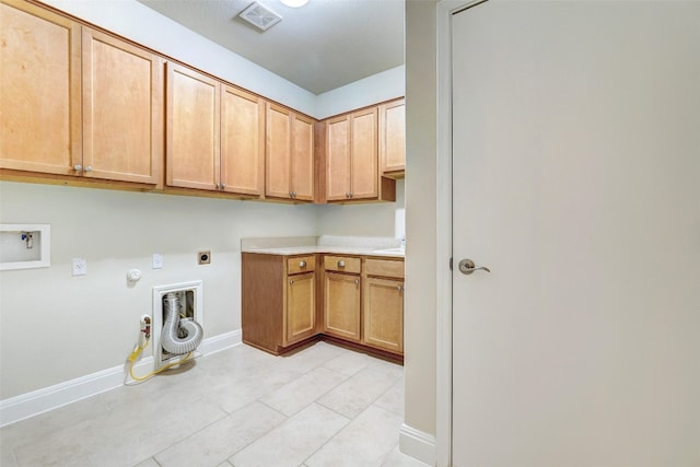 laundry area with hookup for a washing machine, hookup for an electric dryer, light tile patterned floors, hookup for a gas dryer, and cabinets