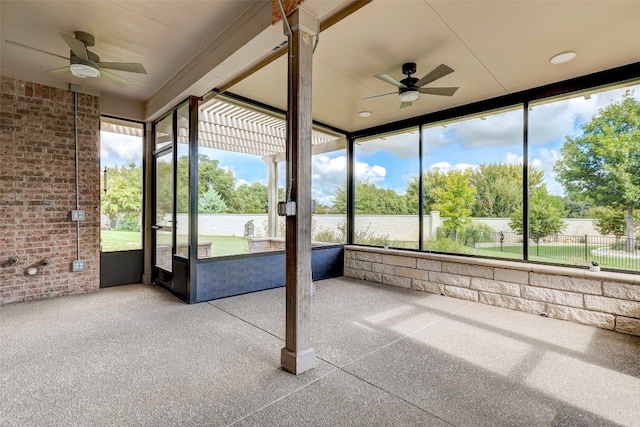 unfurnished sunroom with ceiling fan